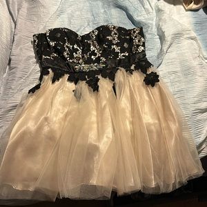 Short strapless dress, black floral pattern top. Overall white/cream color.